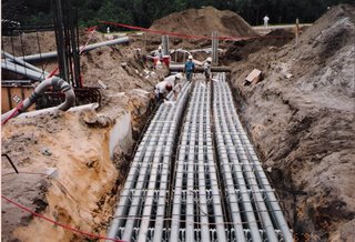 Trench and cable reels staged along a right-of-way for an underground utility run
